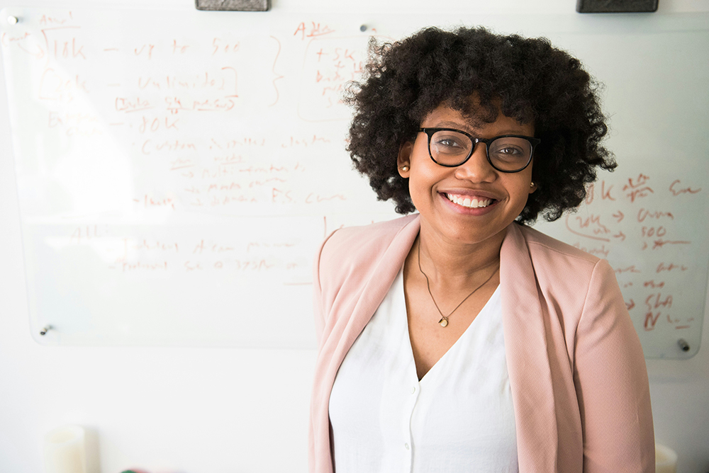 Women stood smiling in front of a white board